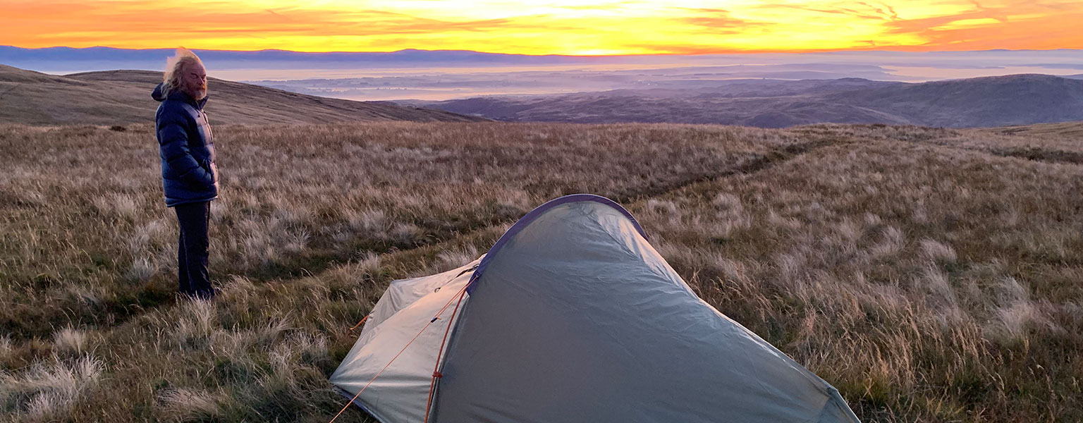 A person stood next to their Vango backpacking tent 