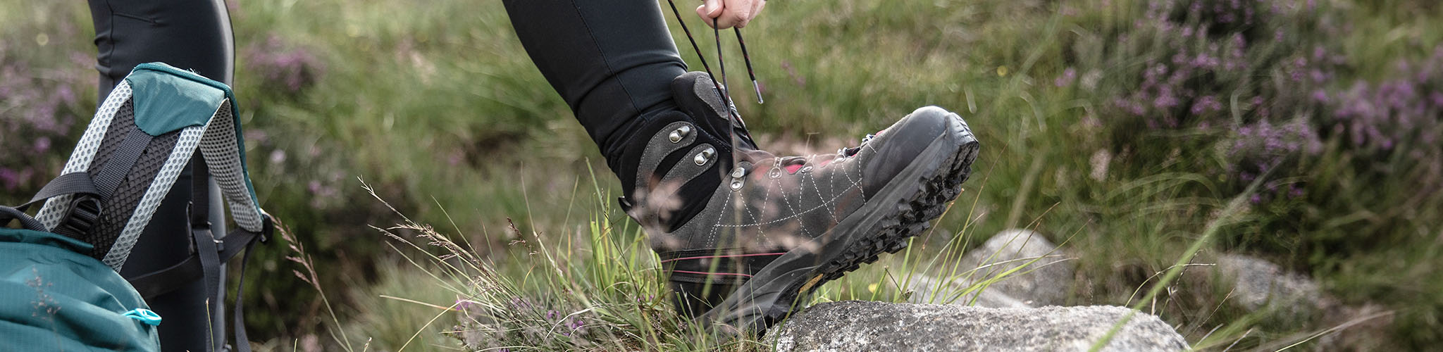 A person tying up their walking boots for a hike
