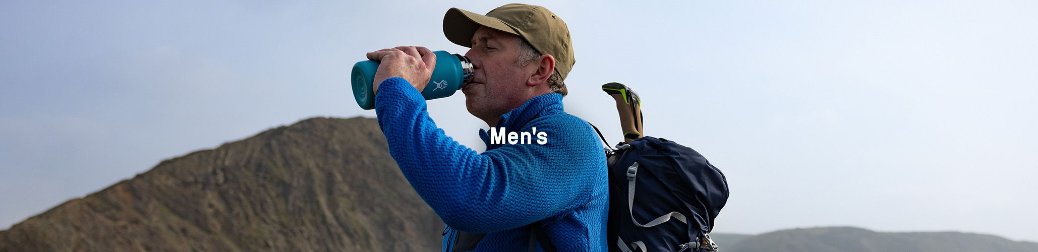 Man drinking from a bottle outdoors