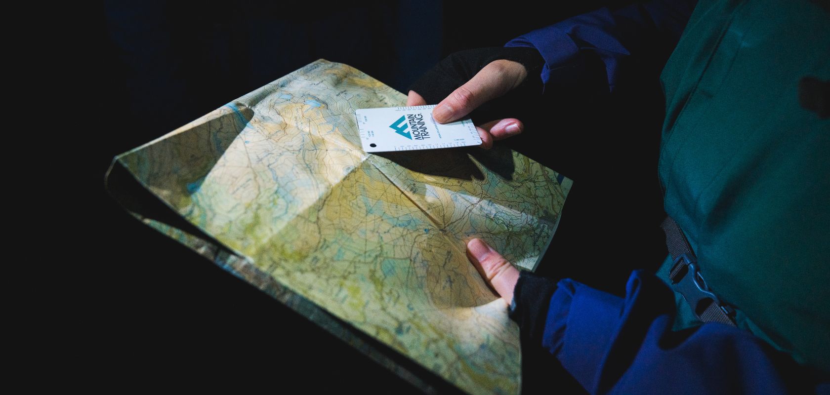 A close up of people looking at coordinates on a map 