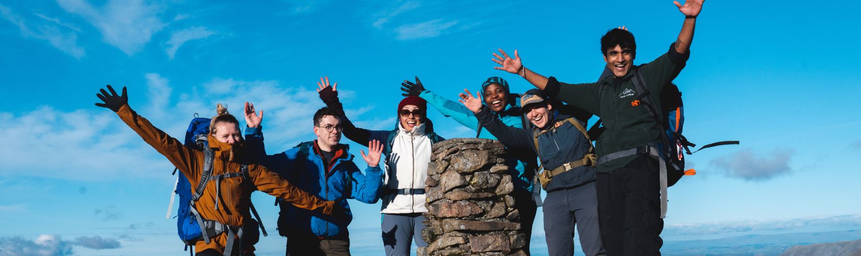 People standing by a tor waving and smiling 