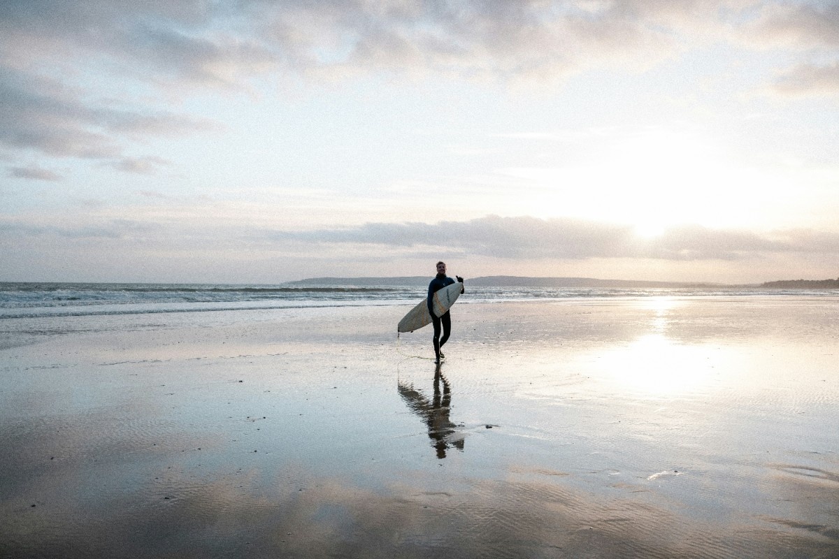 A man with a surfboard on Bournemouth Beach 