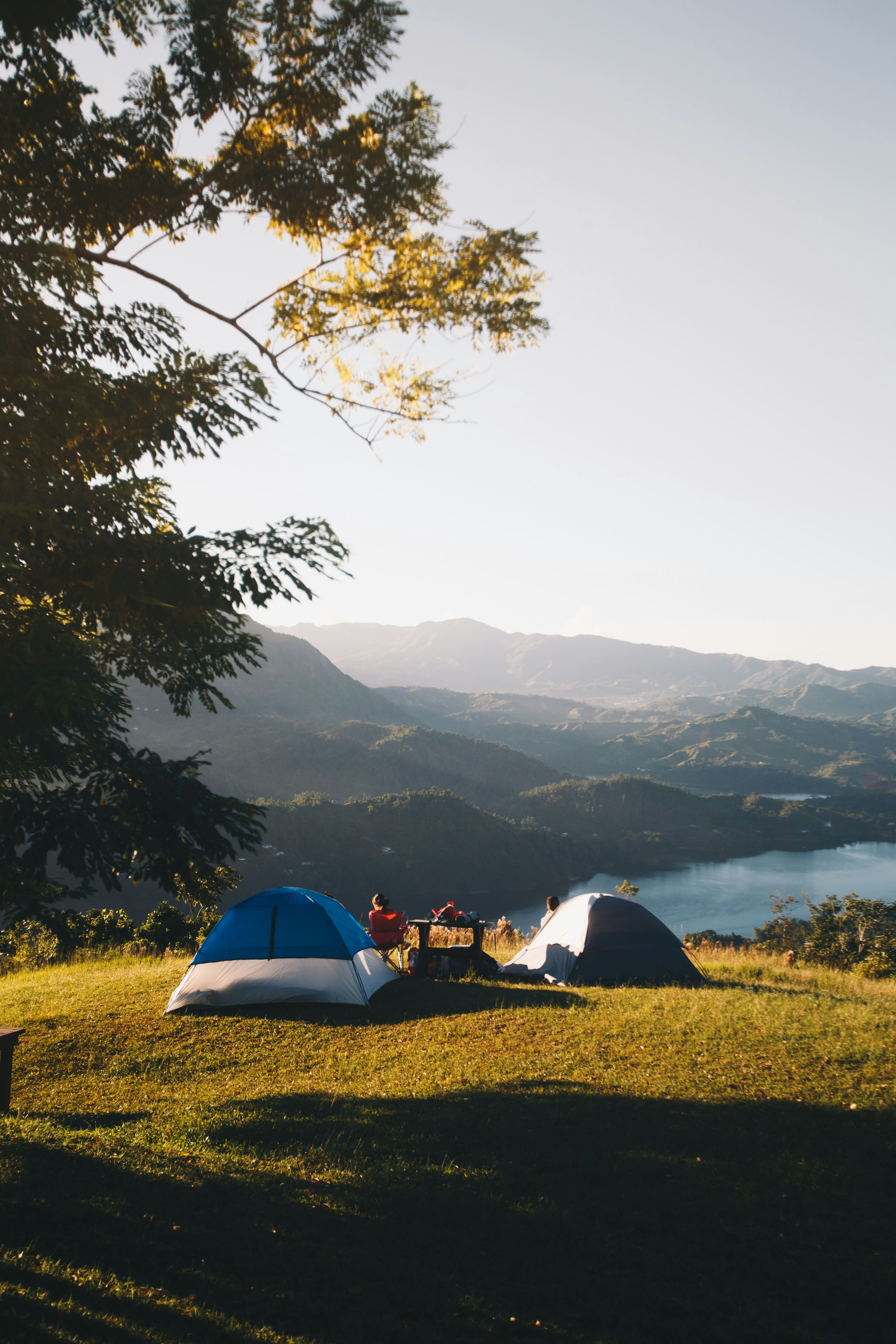 An image of two tents camped by a lake 