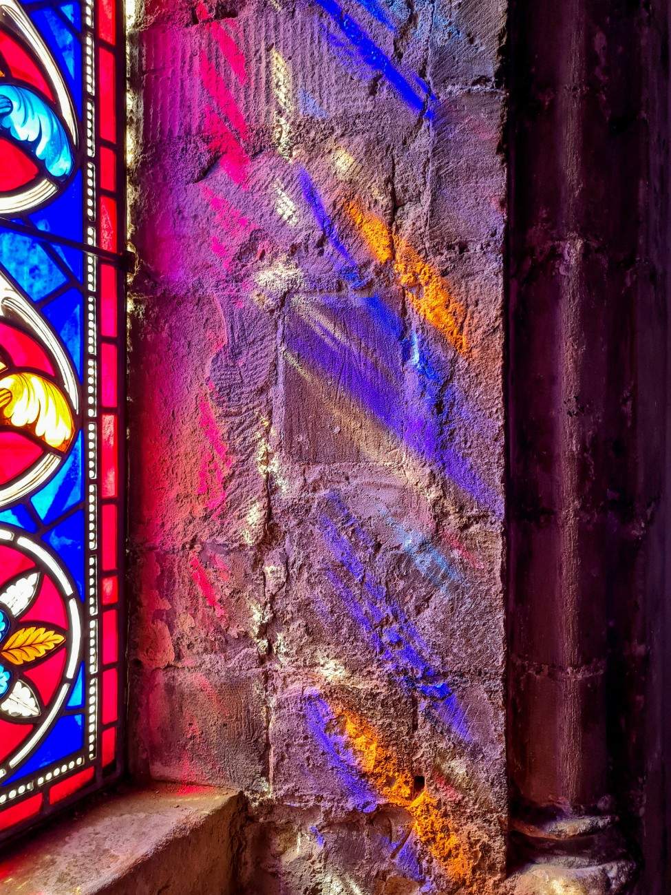 A stained glass window reflecting on the wall in Dover Castle