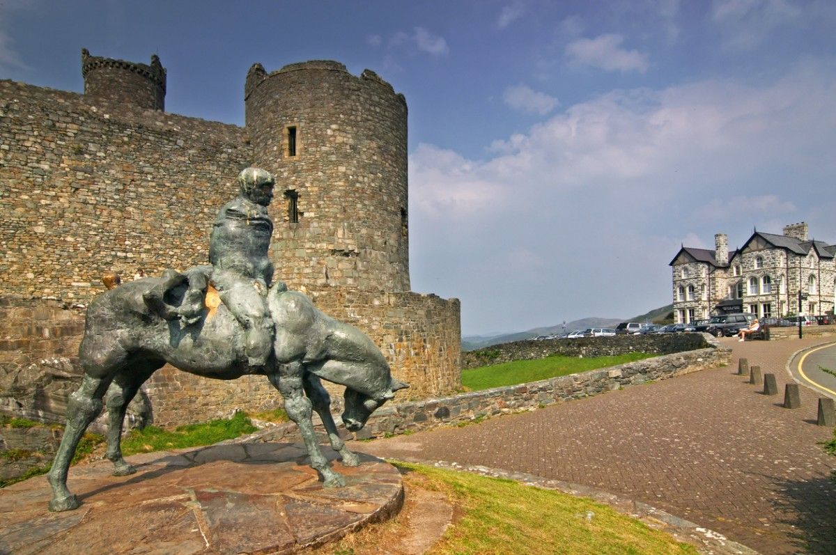 A statue of a knight on a horse outside Harlech Castle