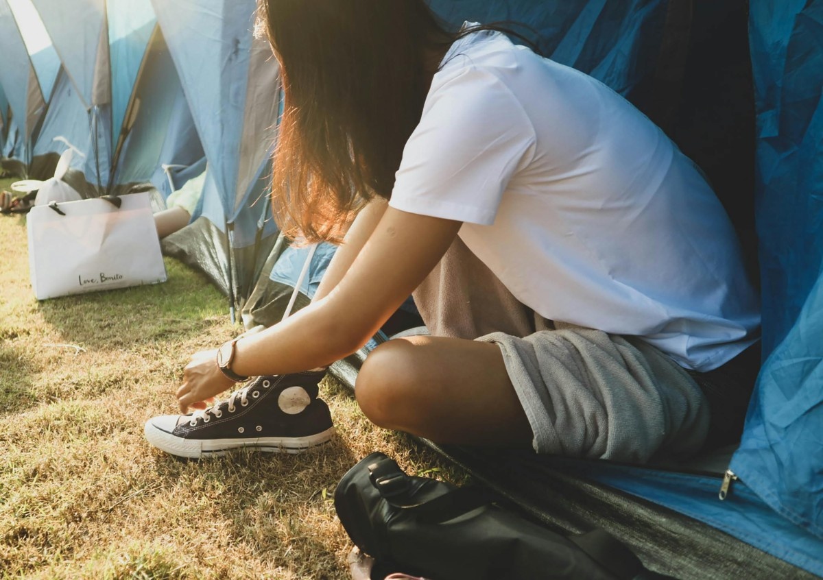 A woman tying up her shoes in a tent