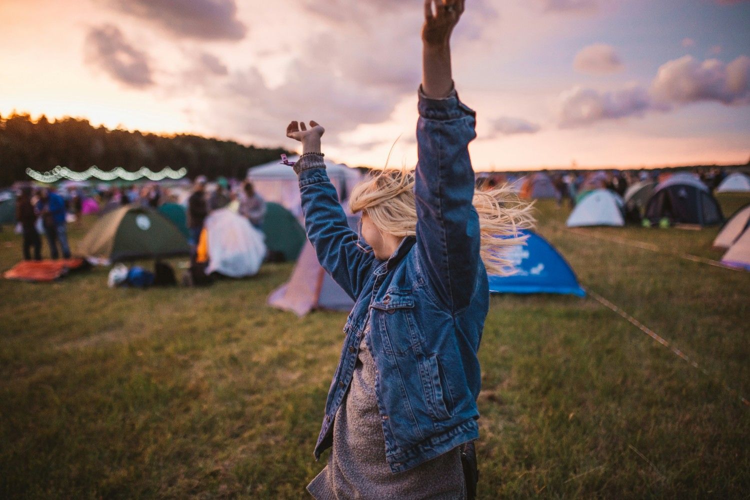 A girl dancing in the campsite at a festival