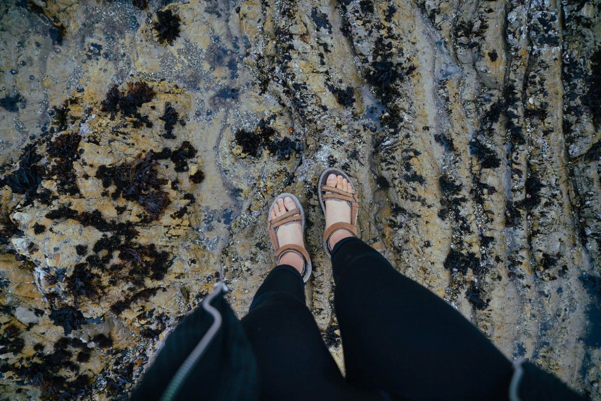 A woman wearing her Teva sandals on the beach 