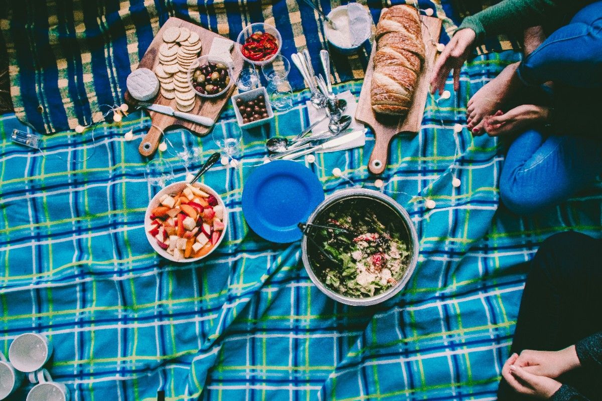 A selection of foods on a picnic blanket 