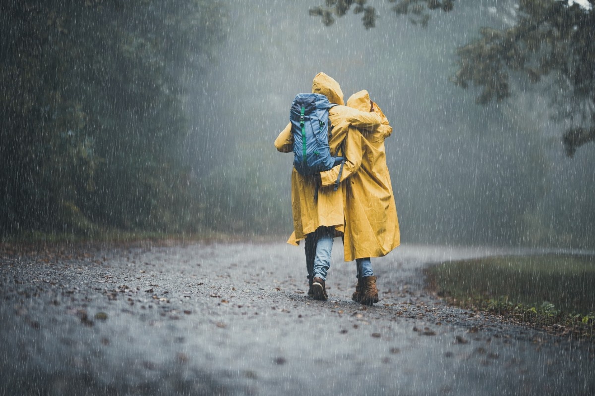 Two people wearing yellow rain coats on a walk in the rain 