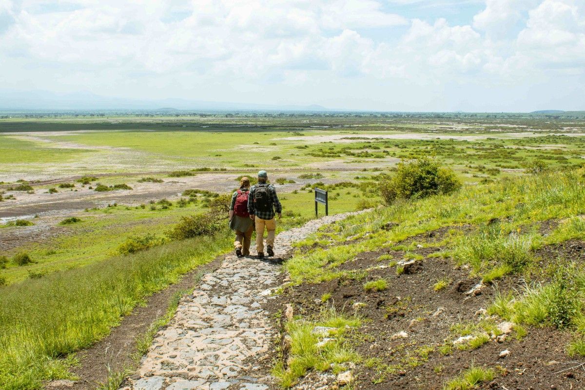 Two backpackers walking through Amboseli National Park 