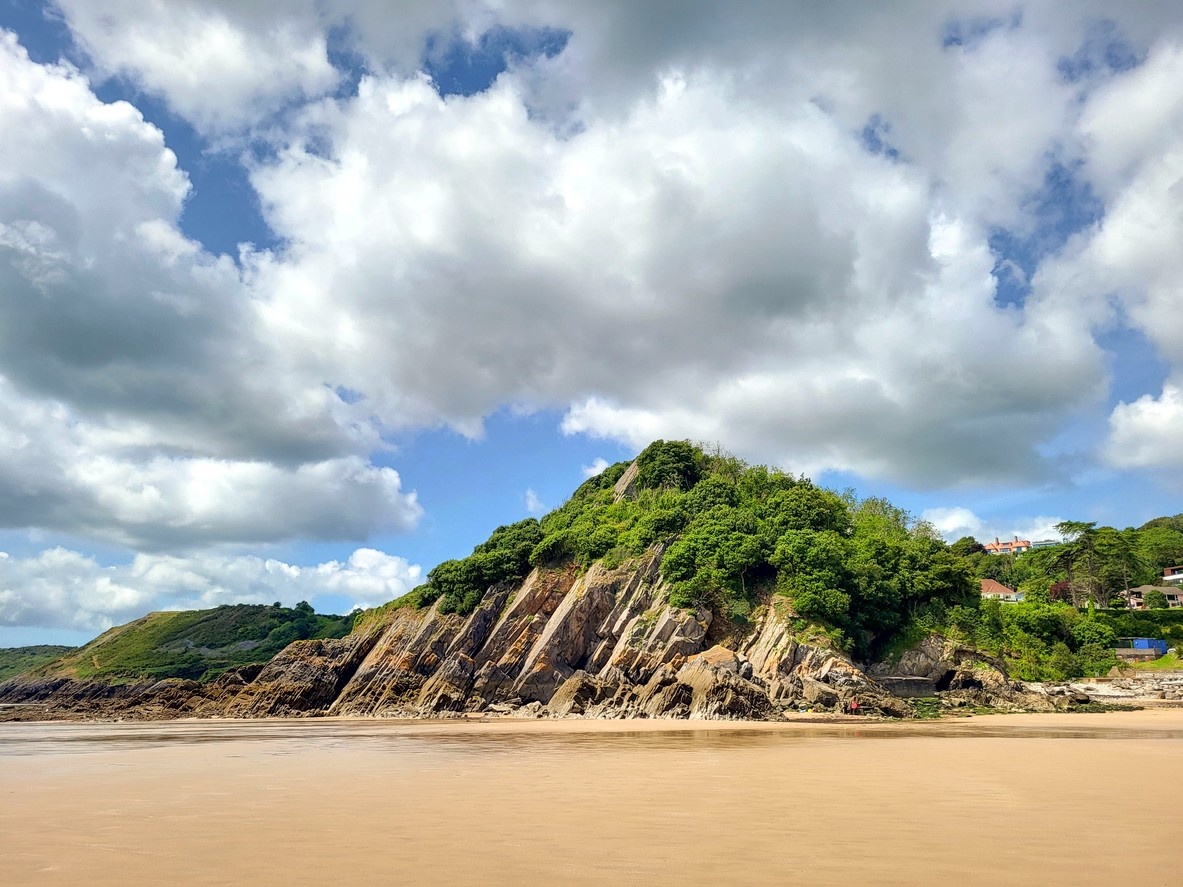 The rocky green cliffs of Caswell beach