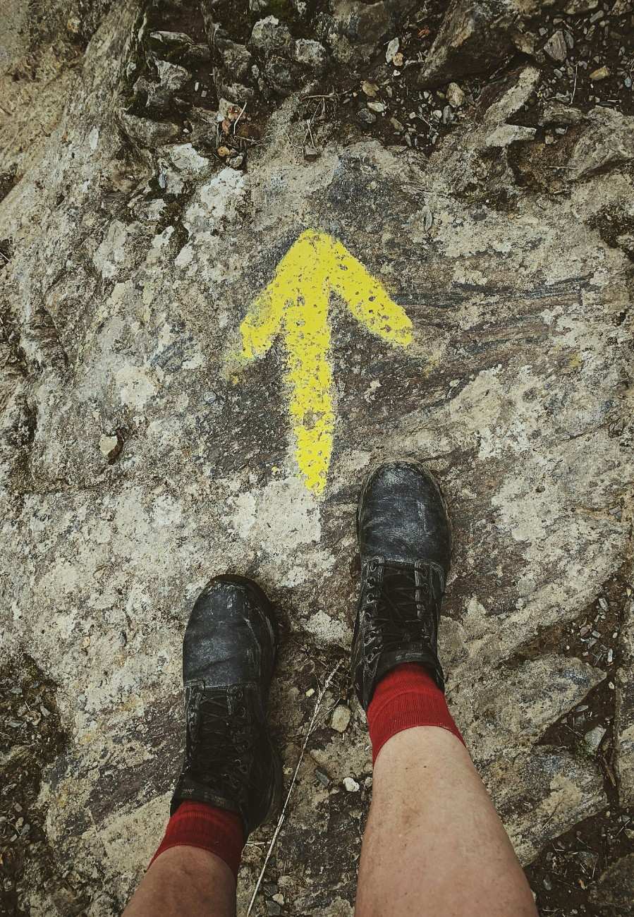 A person wearing walking boots on El Camino de Santiago