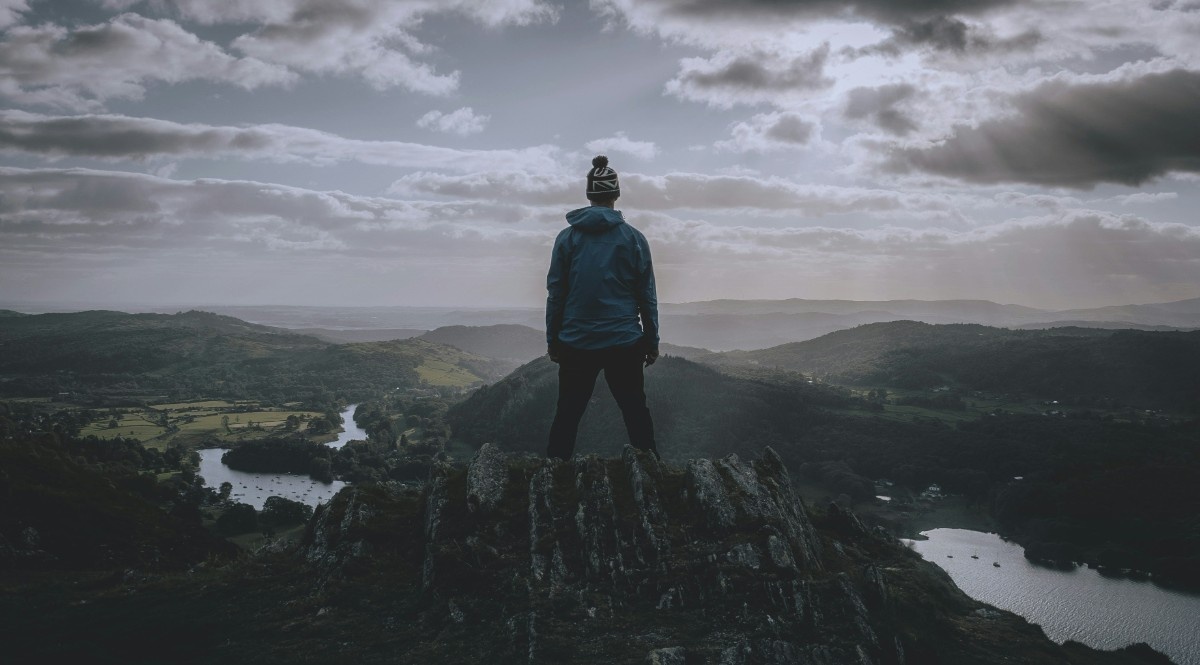 A person stood atop a hill looking out at Lake Windermere