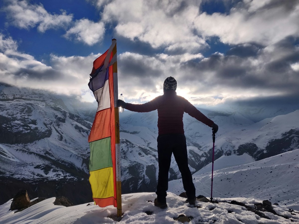 A man standing on the The Thorong La Pass on the Annapurna Circuit