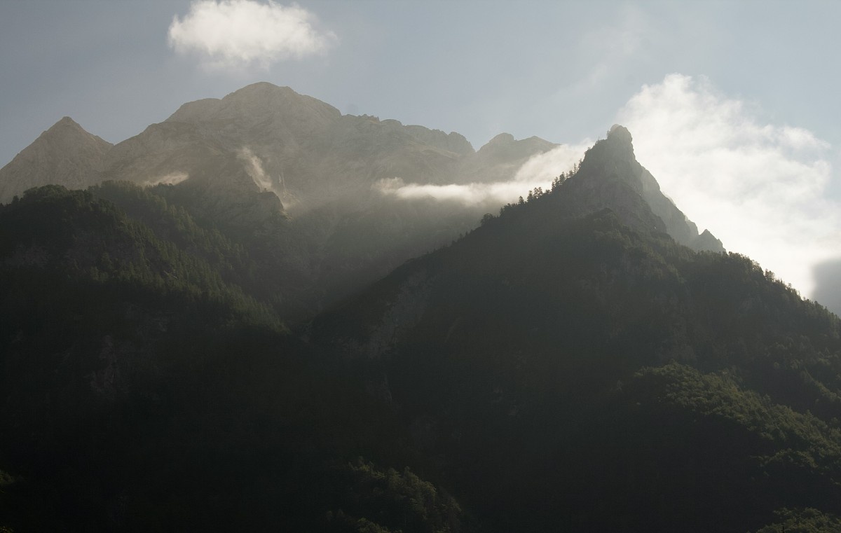 The sun rising over the darkside of a mountain in Triglav