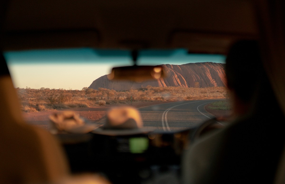 Uluru Mountain through a car window 