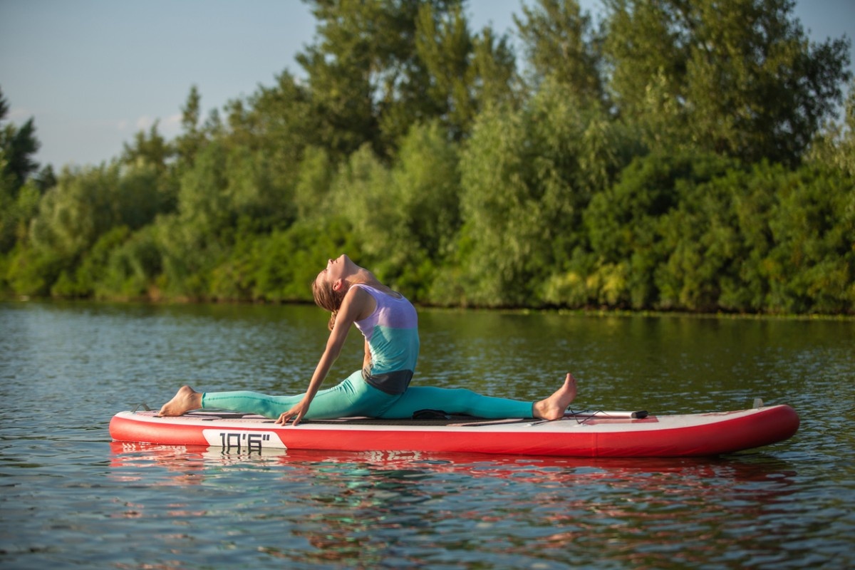 A woman doing the splits in SUP yoga