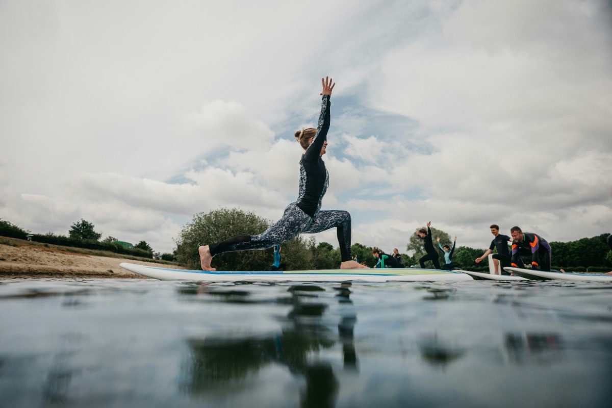 A woman doing a warrior pose of a SUP 