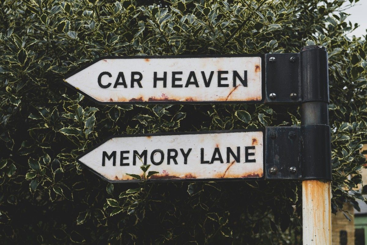 Two signs in Bourton on the Water, one reading "Car Heaven" and one reading "Memory Lane"