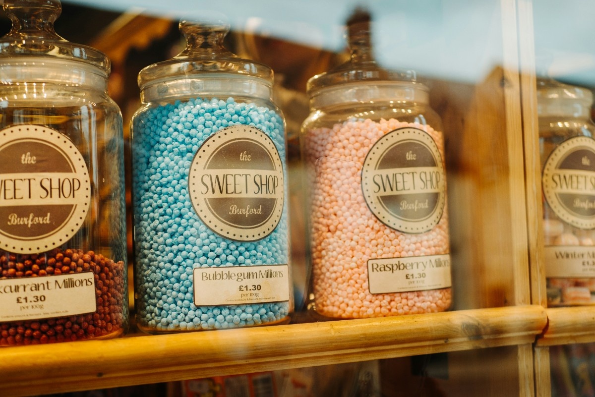 Sweet jars lined up in the shop windon of a sweet shop in Burford