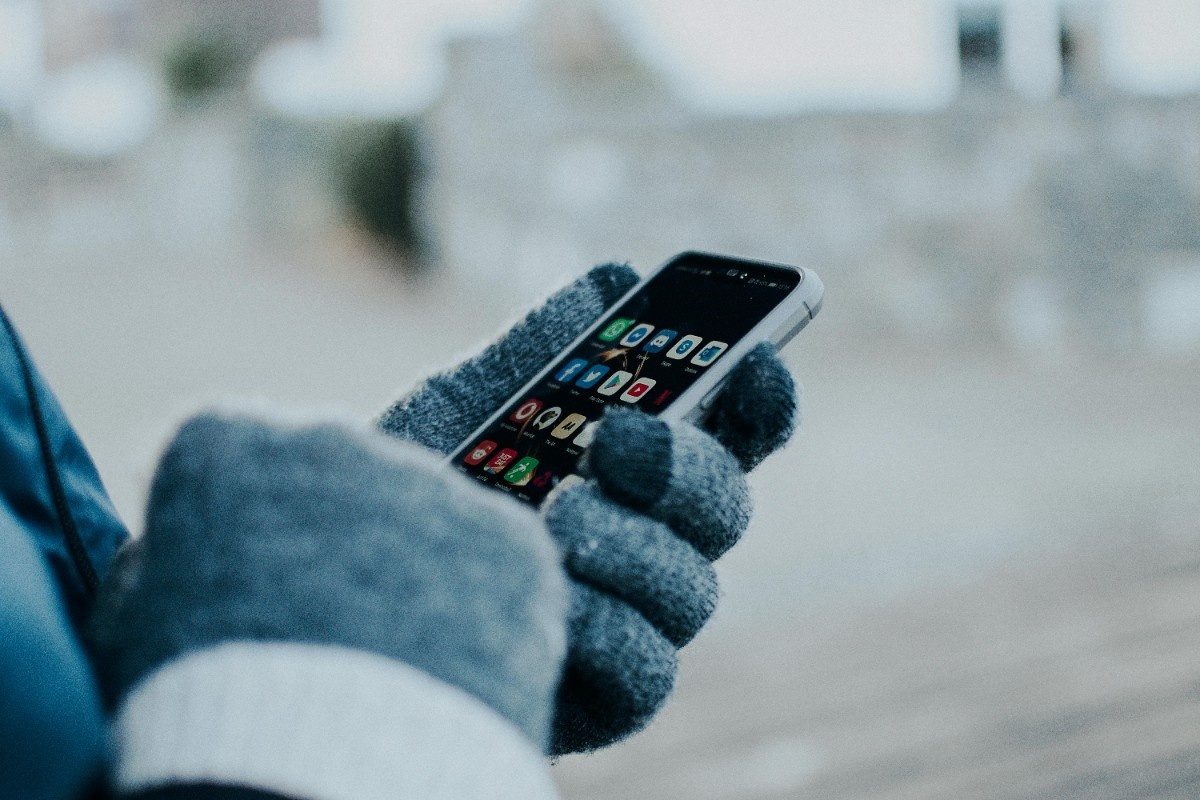 A person using their touchscreen gloves in the cold 