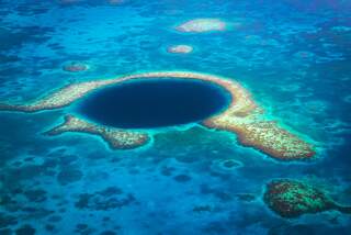 Aerial View to the famous diving site and natural phenomenon the Blue Hole in the Lighthouse Reef, East of the Turneffe Atoll in Caribbean Sea, Belize, Central America.