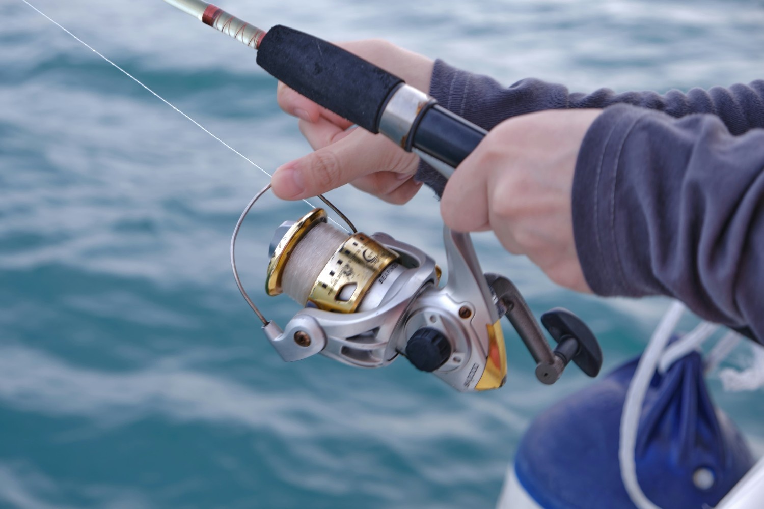 man holding fishing rod on a boat