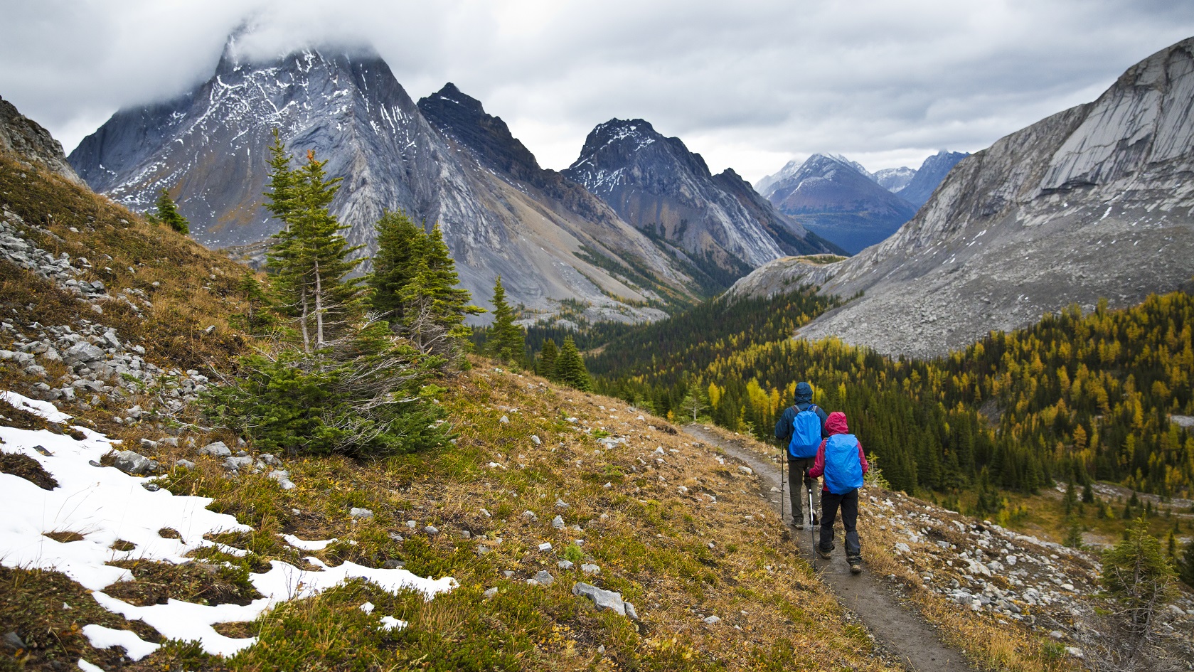 A man and woman enjoy a rainy day hike in Peter Lougheed Provincial Park, Alberta, Canada.